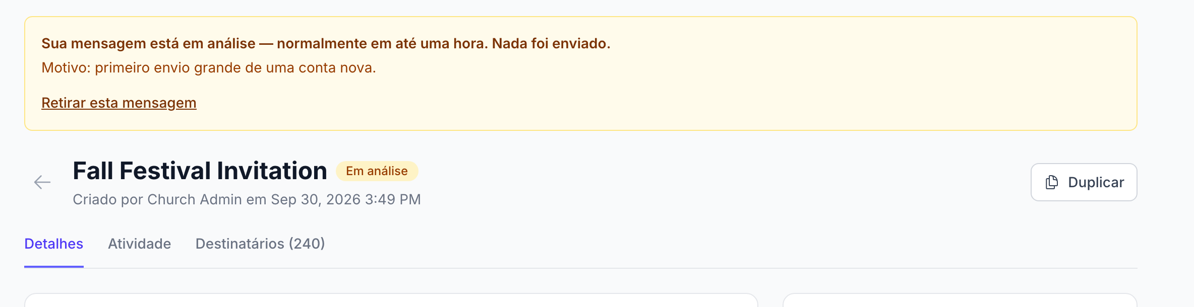 a página de detalhes de uma campanha com o aviso âmbar "Sua mensagem está em análise — normalmente em até uma hora. Nada foi enviado.", a linha "Motivo: primeiro envio grande de uma conta nova." e o link "Retirar esta mensagem"